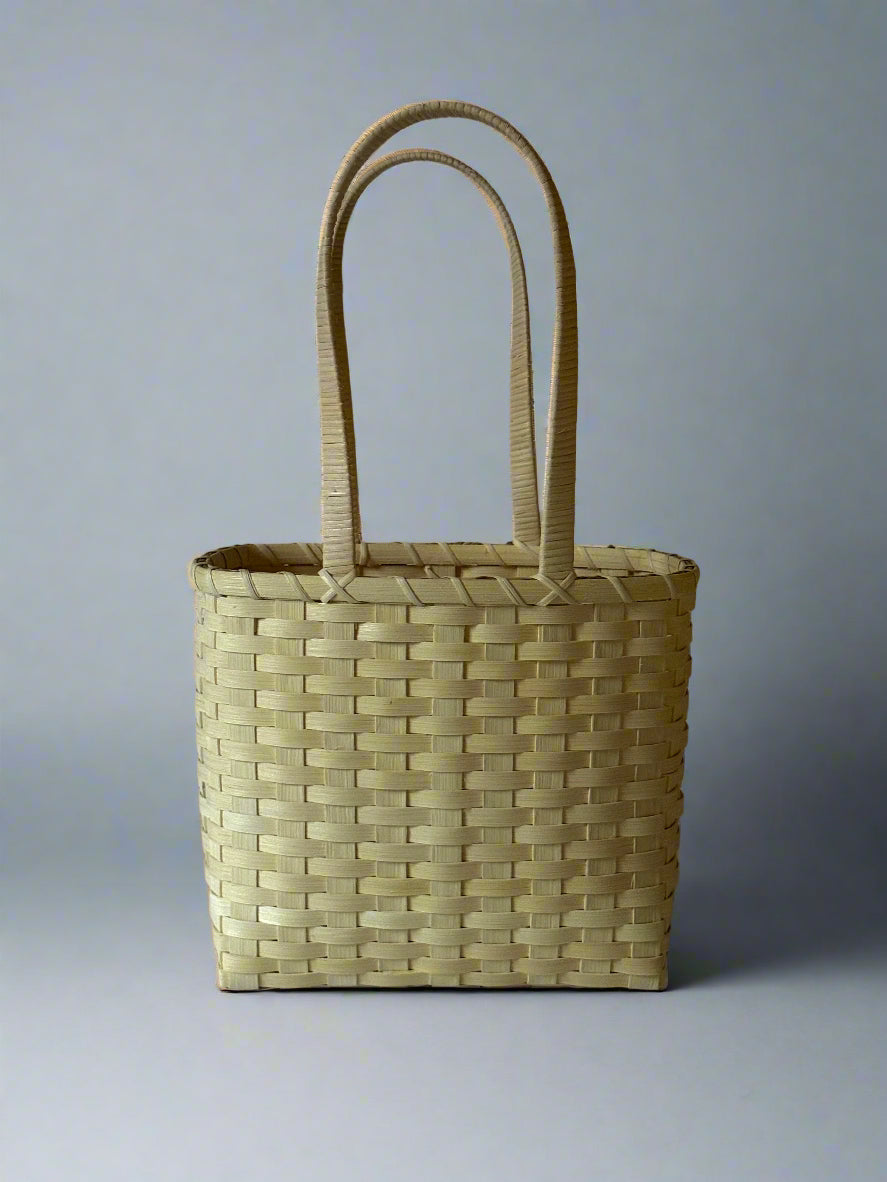 Woven basket with handles on a plain background