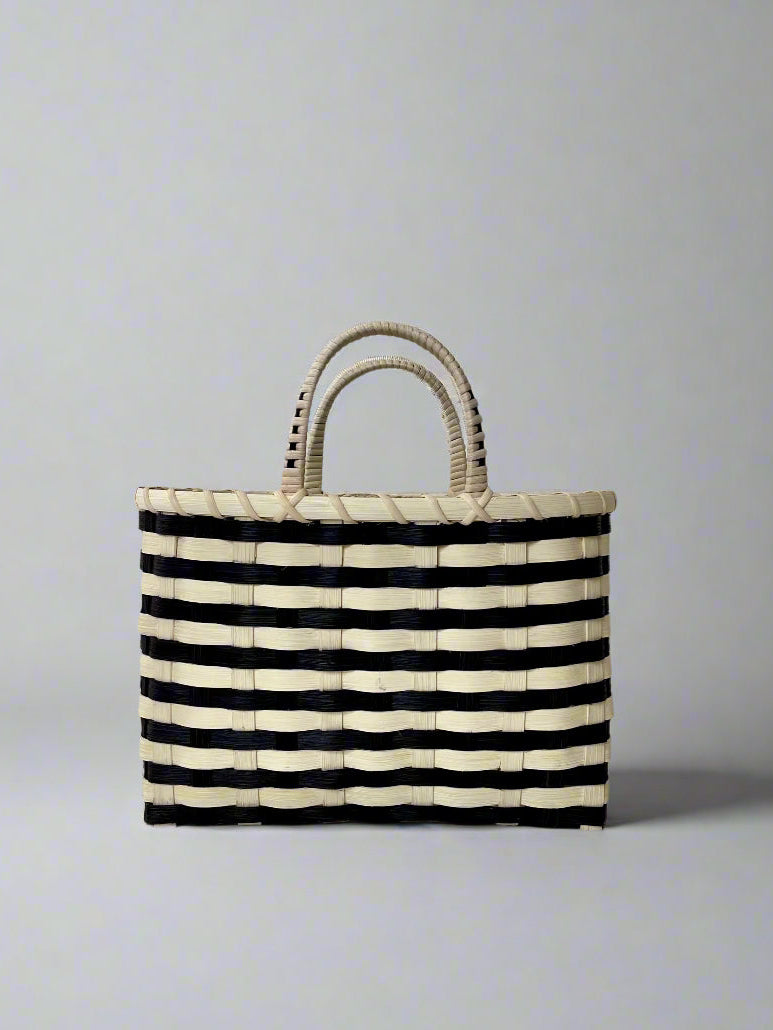 Black and white striped woven bag on a light gray background
