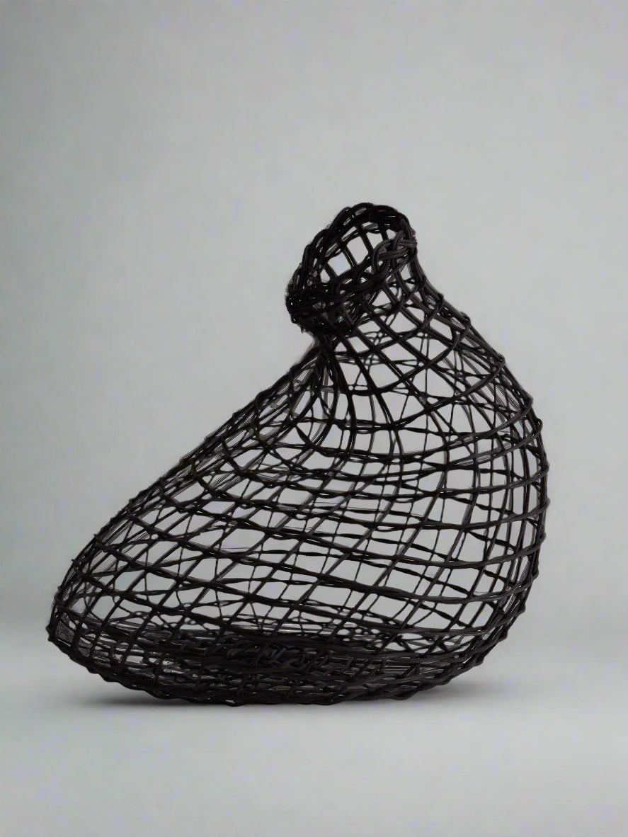 Black wire mesh sculpture of a dog head on a beige background