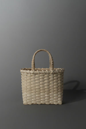 Woven basket with handles on a plain background