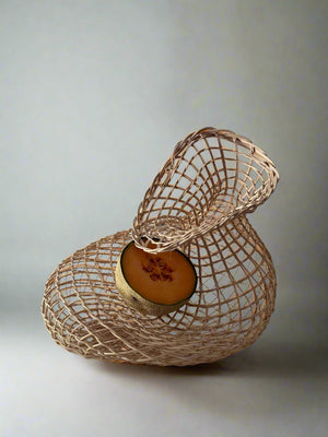 Decorative woven basket with a round wooden base on a light gray background