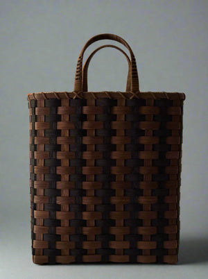 Woven brown bag with handles on a light gray background