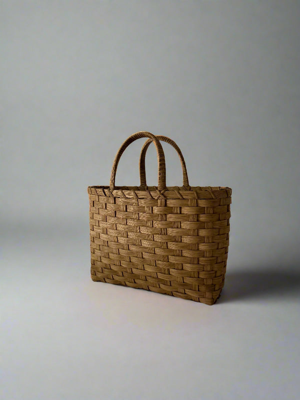 Woven brown bag on a plain background