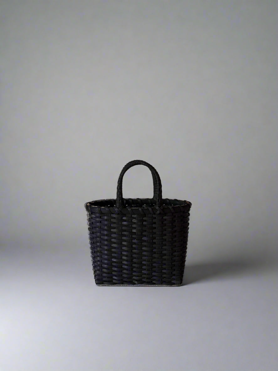 Black woven handbag on a light gray background