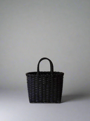 Black woven handbag on a light gray background