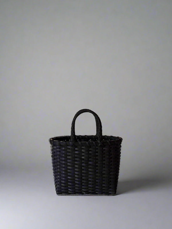 Black woven handbag on a light gray background