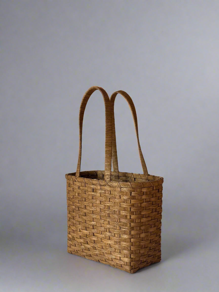 Woven basket with handles on a plain background