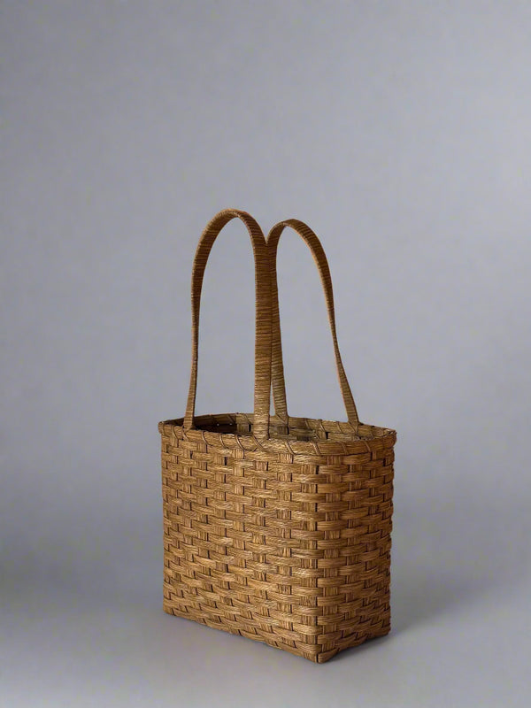 Woven basket with handles on a plain background