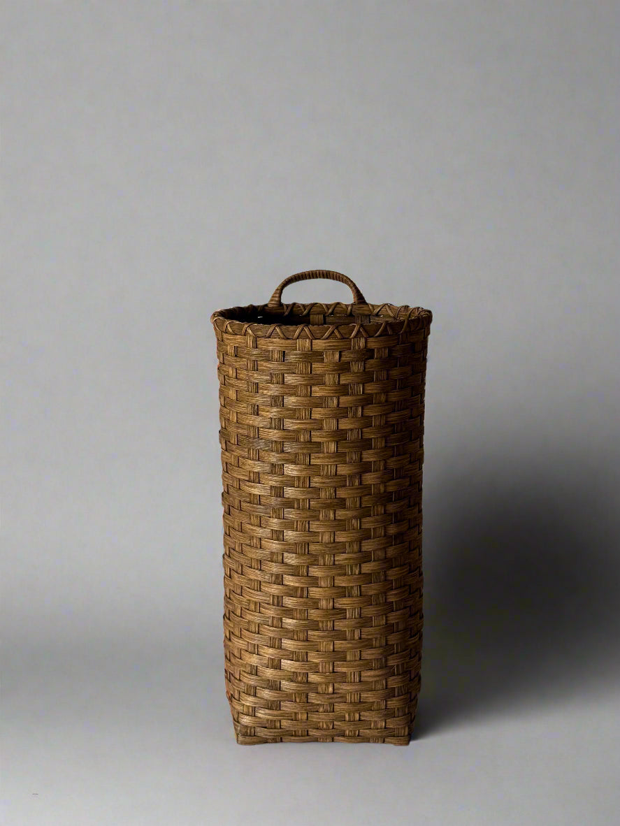 Woven basket with a handle on a white background