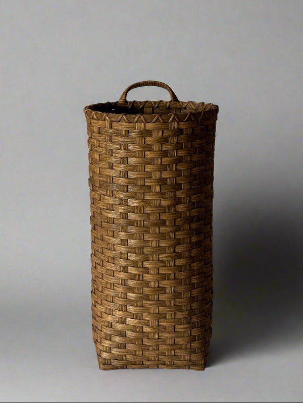 Woven basket with a handle on a white background