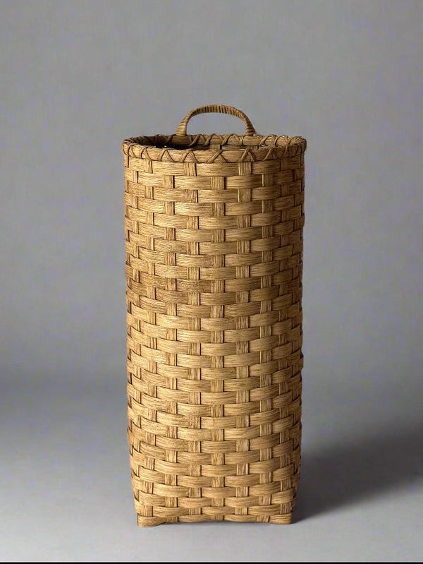 Woven basket with a handle on a plain background