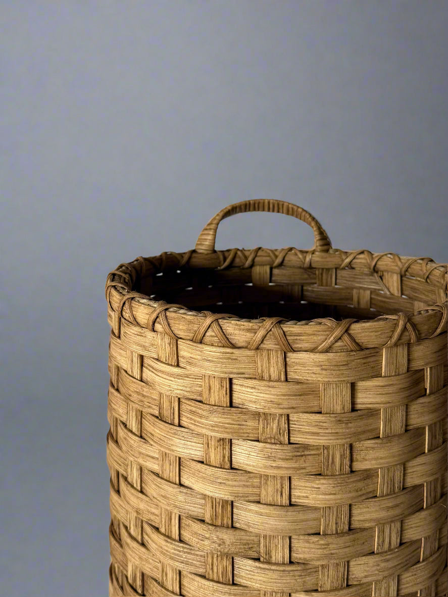 Woven basket with handles on a plain background