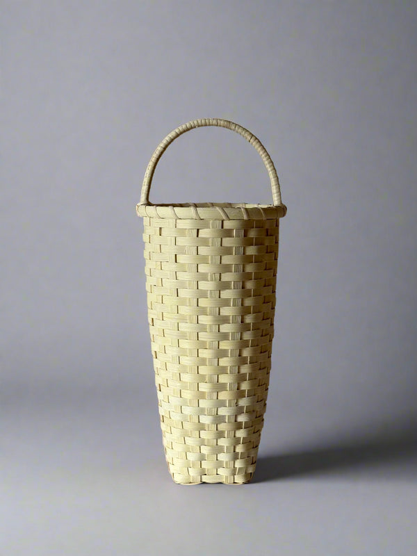 Woven basket with a handle on a gray background