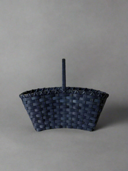 Woven basket with a handle on a light gray background