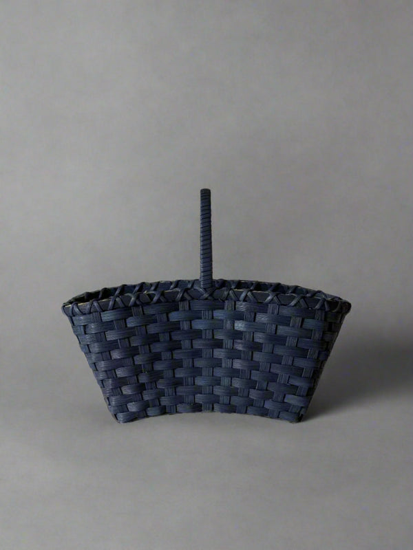 Woven basket with a handle on a light gray background
