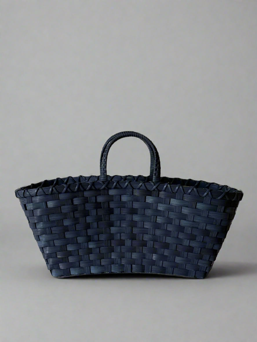 Black woven basket on a beige background