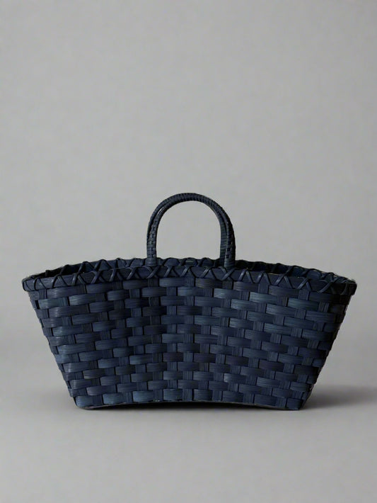 Black woven basket on a beige background