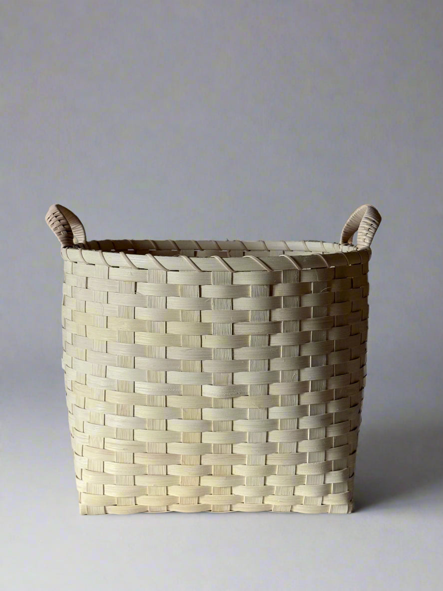 Woven basket with handles on a gray background