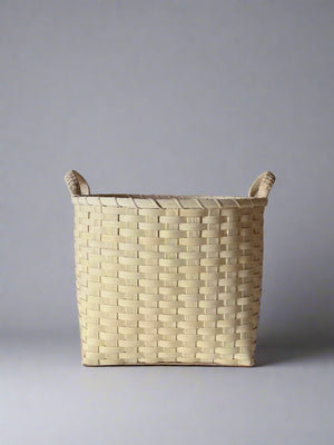 Woven basket with handles on a plain background