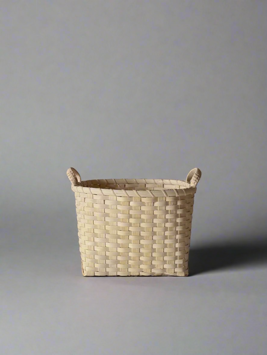 Woven basket with handles on a plain background