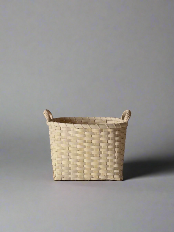 Woven basket with handles on a plain background