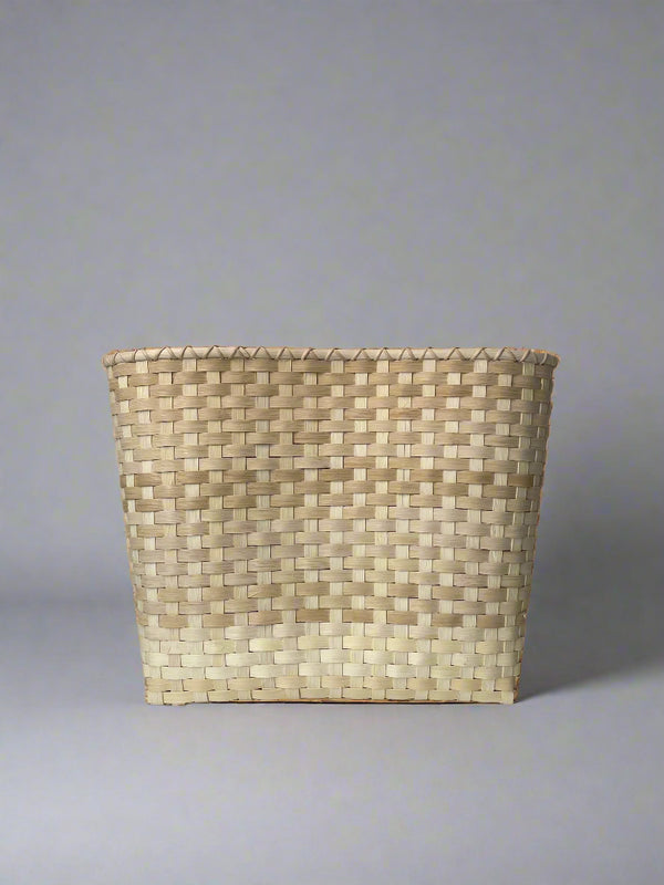 Woven basket made of natural fibers on a plain background