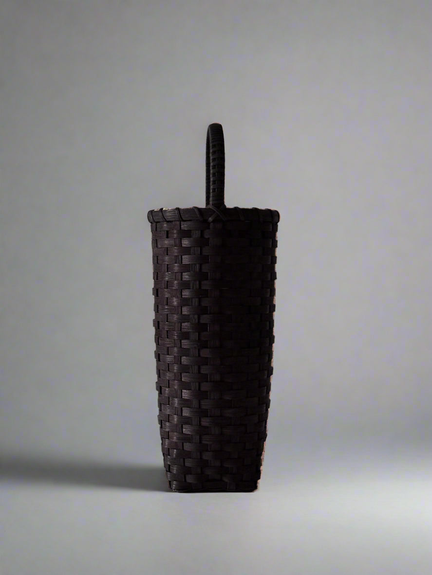 Dark woven basket on a light gray background