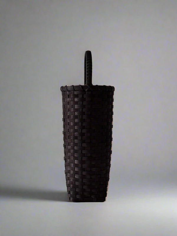 Dark woven basket on a light gray background