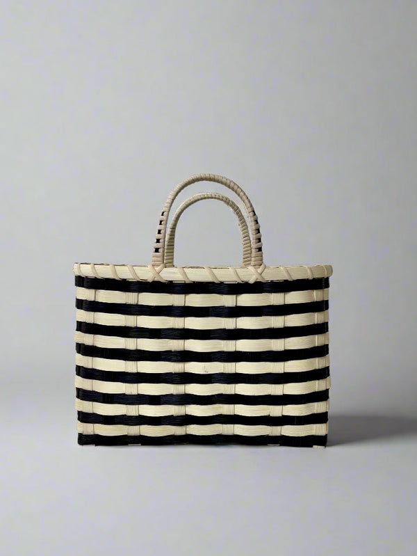 Black and white striped woven bag on a light gray background