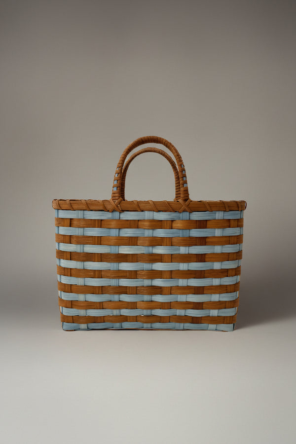 Woven basket with striped pattern on a plain background